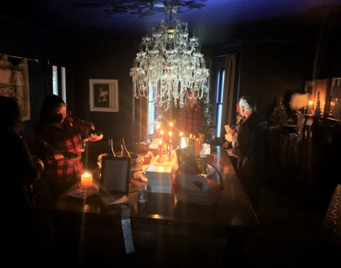Photo of a staff member pouring wine by candlelight during the Holiday Sip & Savour Open House in 2021 during a power outage