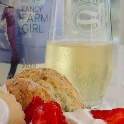 Sue-Ann Staff Sparkles & Scone image featuring a glass of Fancy Farm Girl Frosty Fizz, a scone, strawberries and whipped cream. 