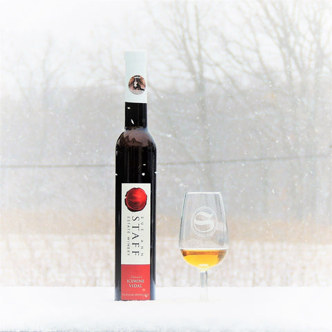 Photo of a bottle of Howard's Icewine Vidal and a glass of icewine outside in the snow