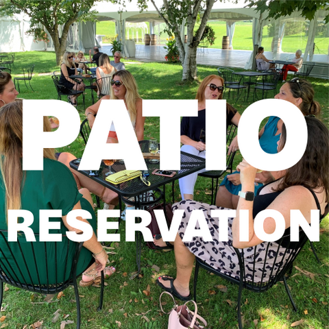 Outdoor patio dining scene with multiple people seated at black metal tables on a grassy lawn under white pergola tents. Large white text overlay reads 'PATIO RESERVATION'.