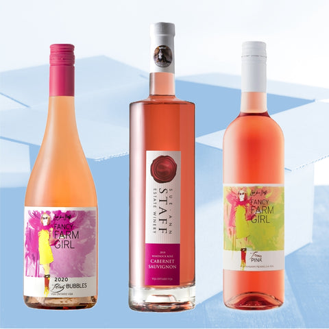Three bottles of pink wine with colorful labels on a blue and white background