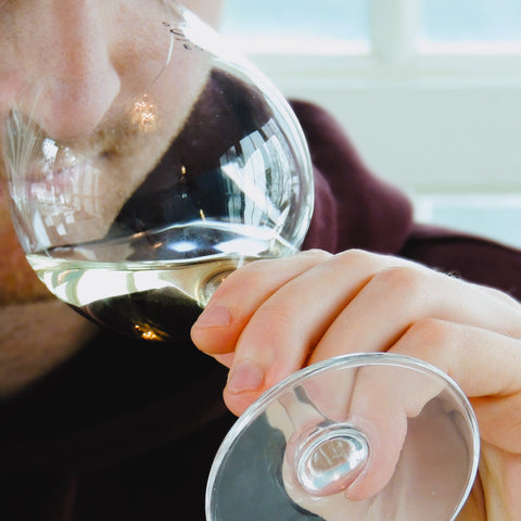 Person holding a wine glass with a blurred background
